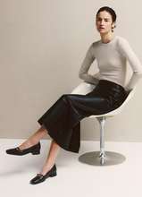 Load image into Gallery viewer, woman wearing black patent pumps with black skirt and white top