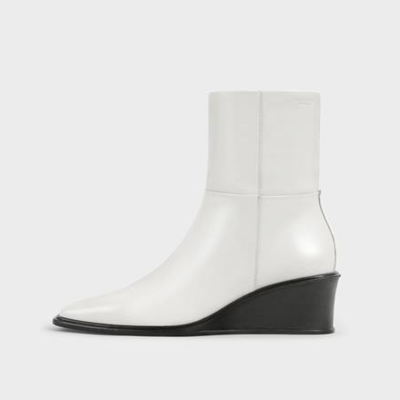 side view of white leather boot with black wedge heel