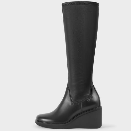 Side view of black knee high stretch boot with wedge heel