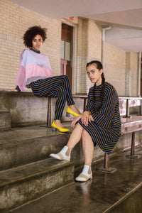 Models wearing yellow pumps and White leather and beige suede Chelsea Boots