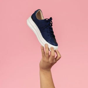 Model holding Navy nubuck and embossed leather chunky sneaker